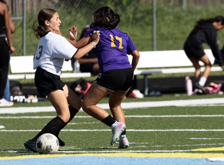 girls soccer player shielding ball from defender during match Midwest City Oklahoma