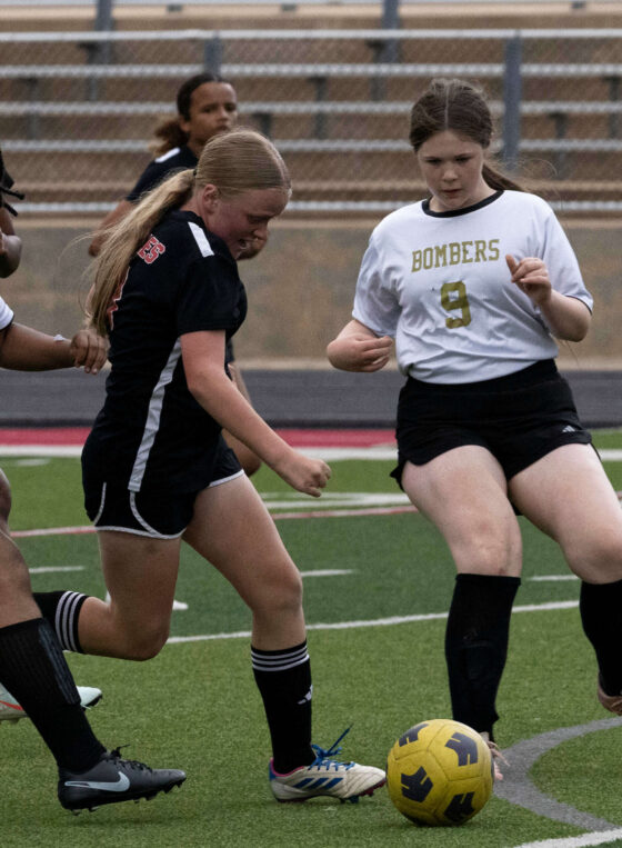 Midwest City middle school girls soccer players challenge a Del City player for possession during a match