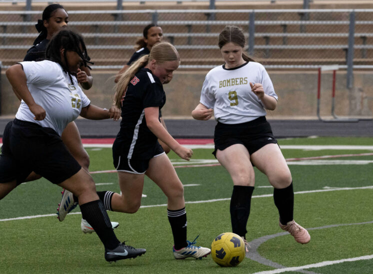 Midwest City middle school girls soccer players challenge a Del City player for possession during a match