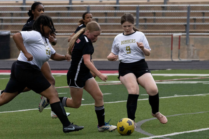 Midwest City middle school girls soccer players challenge a Del City player for possession during a match