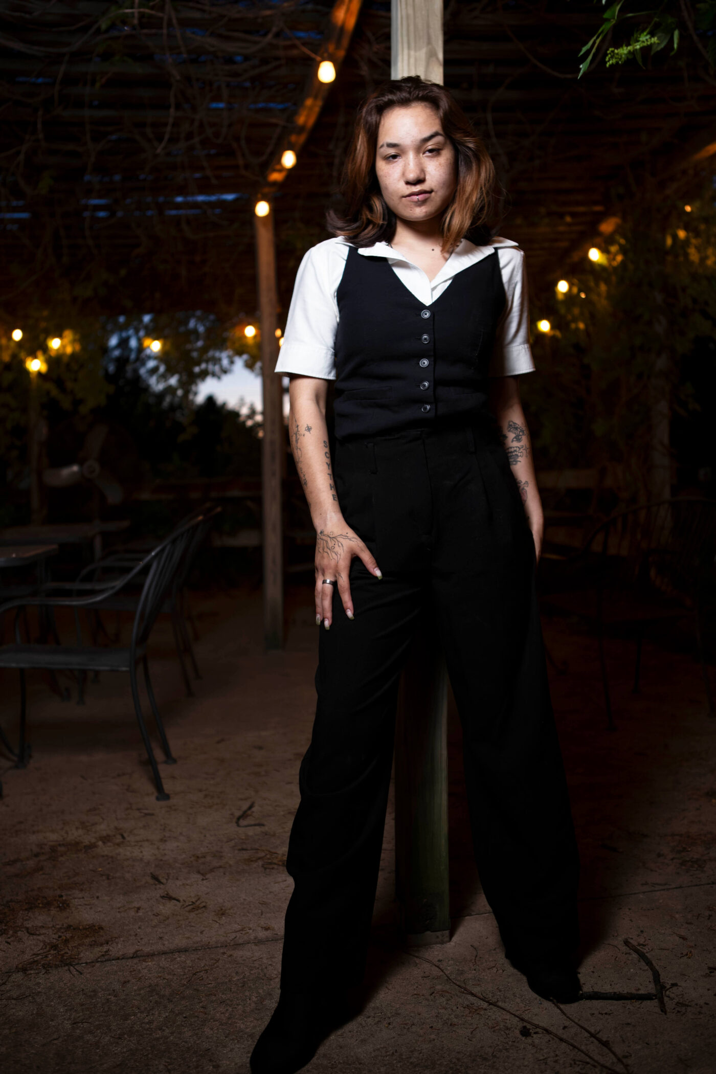 Fashion-style portrait of toxicwoman55 standing confidently beneath hanging lights at Castle Falls during a 1940s-themed photography event.