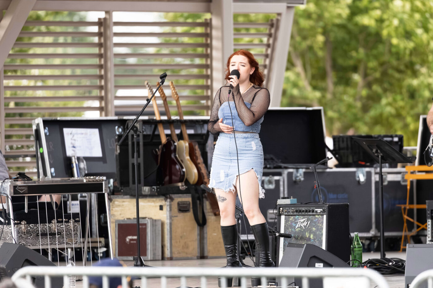 OK3 performers smile and interact on stage during a live concert at Scissortail Park.