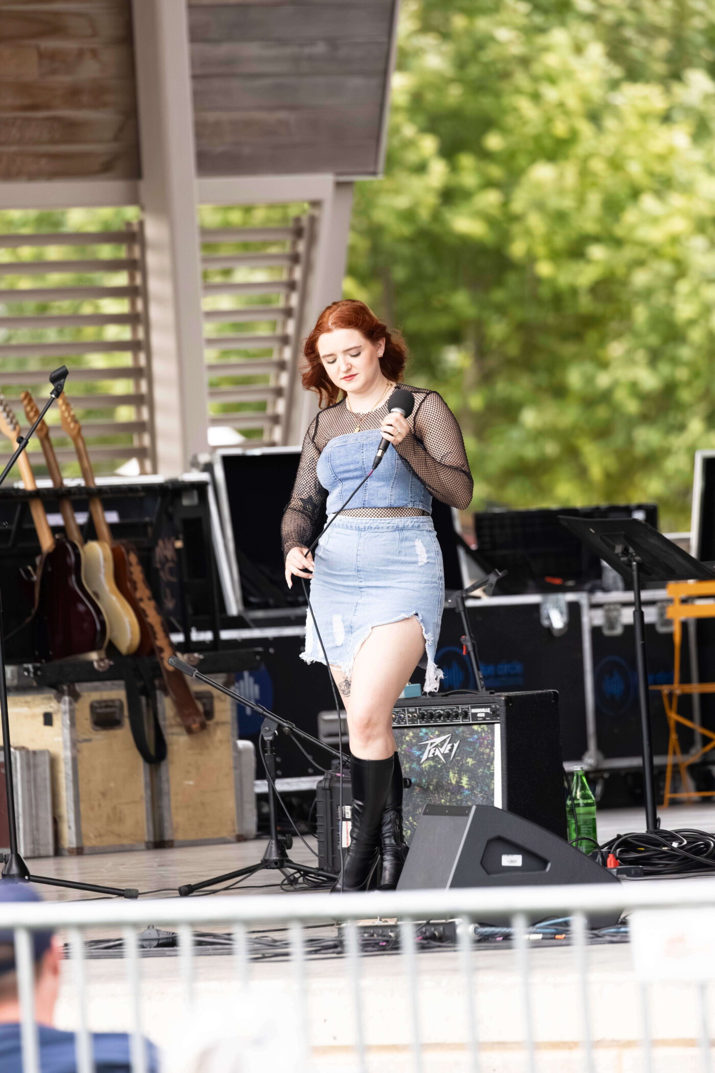 Female singer from OK3 performs alongside guitarist during an outdoor concert at Scissortail Park.