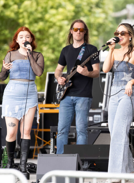 OK3 vocalist walks across the stage holding a microphone during a live performance.