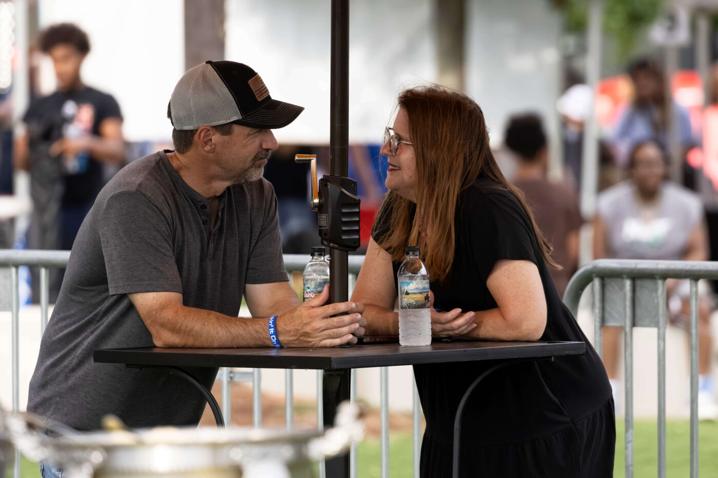 A couple shares a quiet conversation at a standing table during the Kickin' It On Route 66 Centennial Celebration in Oklahoma City.