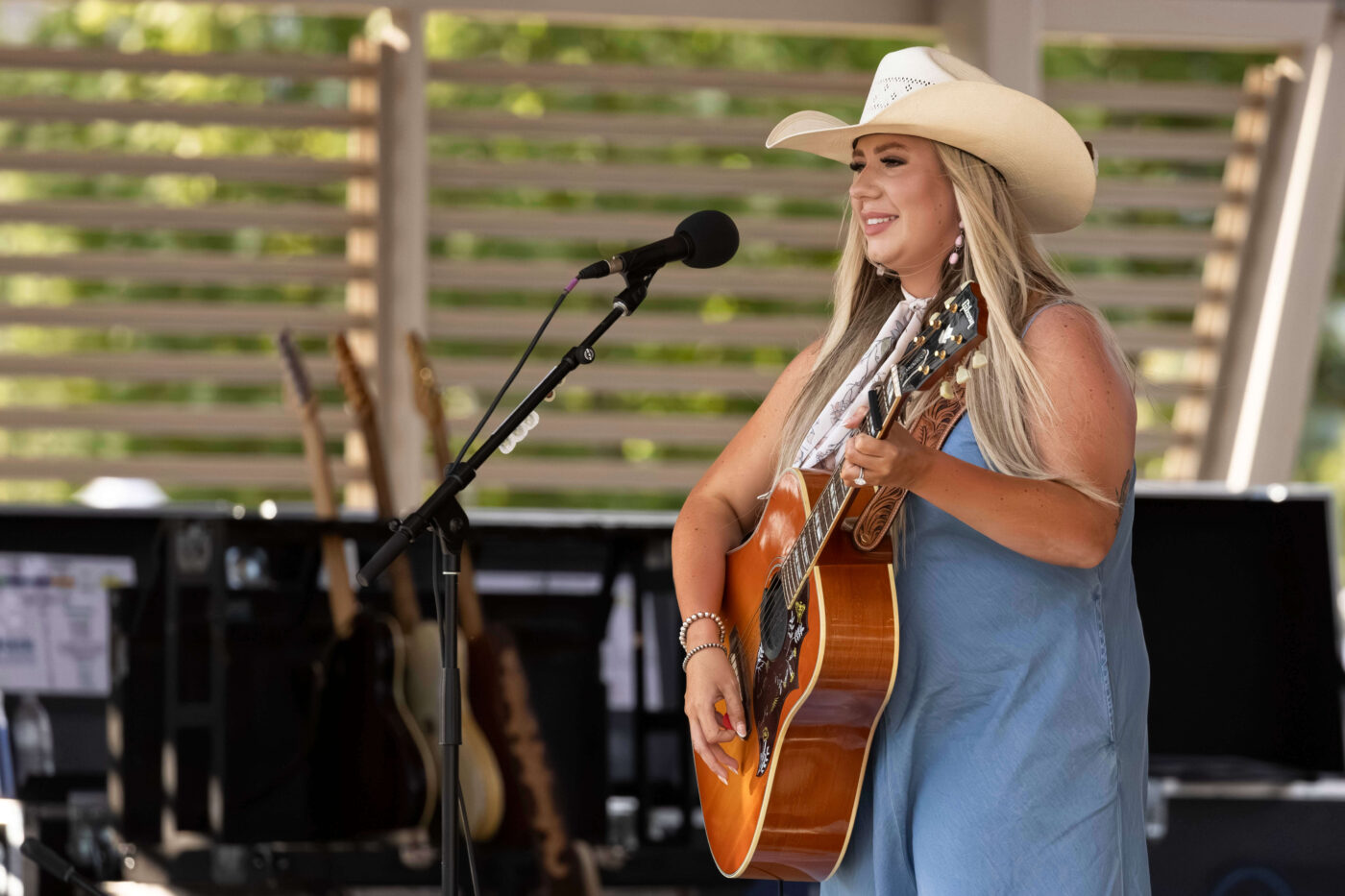 Country music artist Bailey Rae performs on stage with an acoustic guitar during the Route 66 Centennial Celebration.