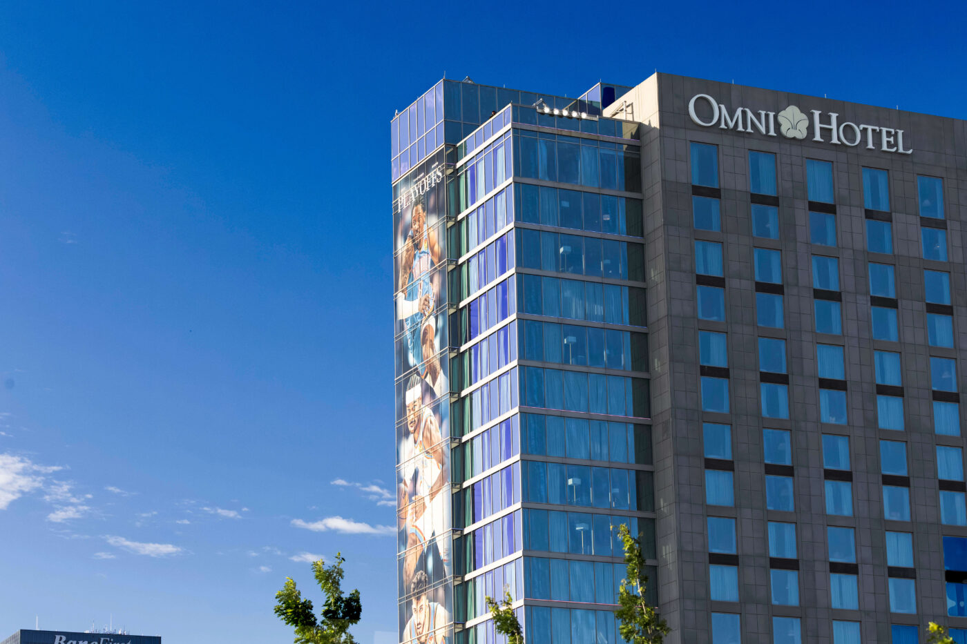 The Omni Oklahoma City Hotel rises against a clear blue sky near Scissortail Park in downtown Oklahoma City.