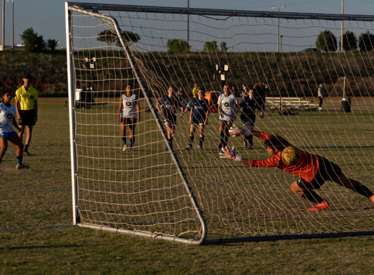 Amarillo Rush player prepares to celebrate after scoring a penalty kick past the diving West Side Alliance goalkeeper during a U16 Girls Gold Division match at the 2026 NOKC Spring Finale