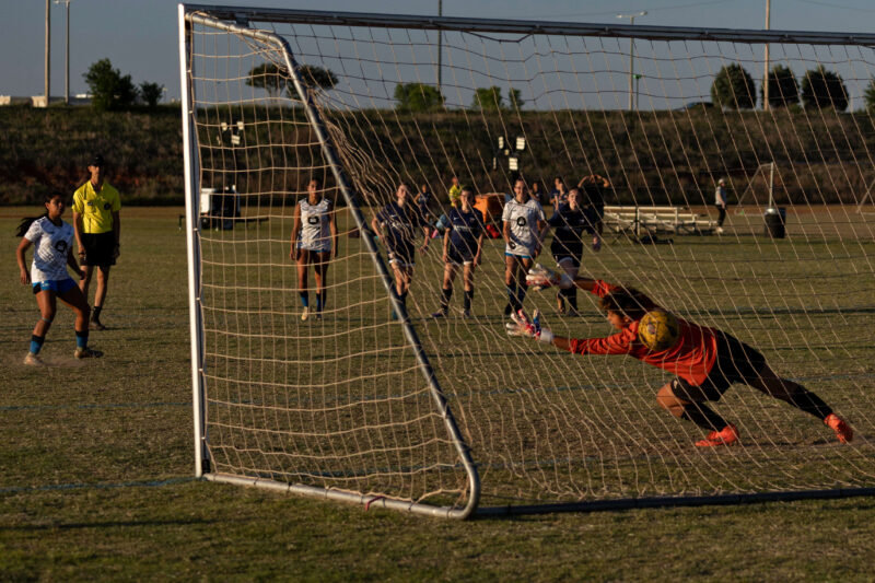Amarillo Rush player prepares to celebrate after scoring a penalty kick past the diving West Side Alliance goalkeeper during a U16 Girls Gold Division match at the 2026 NOKC Spring Finale