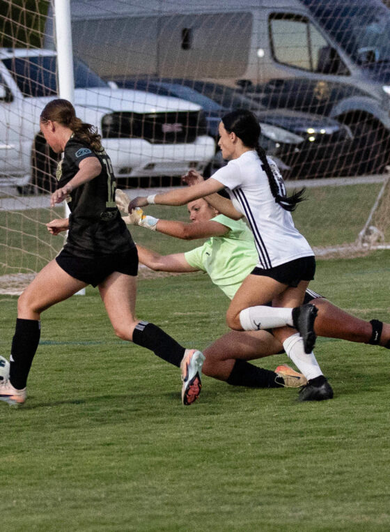 Midwest City Vision player in black attacks near the goal while an Oklahoma Energy defender and goalkeeper attempt to stop the play during a U16 Girls Gold Division match at the 2026 NOKC Spring Finale