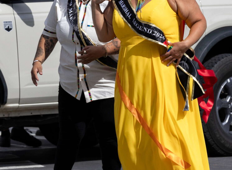 Two parade marshals walk together and smile during the Oklahoma City Pride Parade.