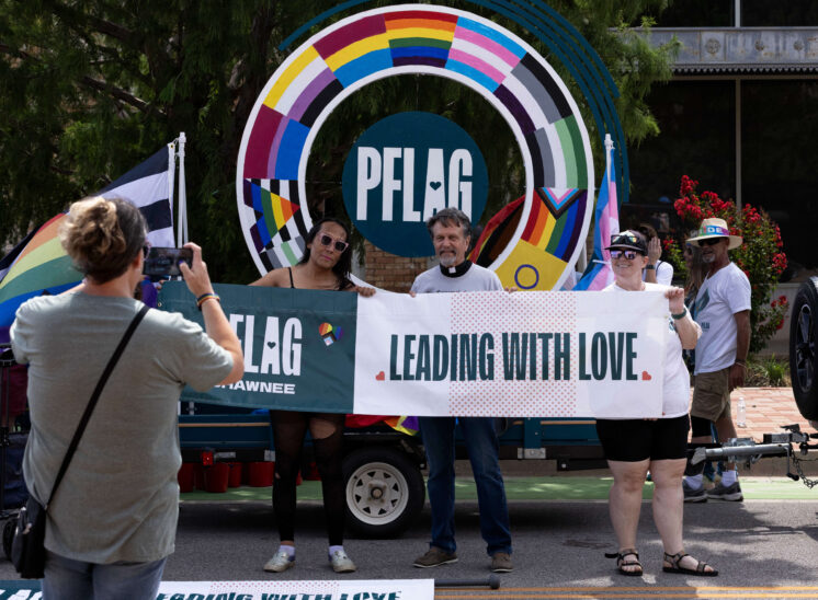 Community members hold a Leading With Love banner during the Oklahoma City Pride Parade.