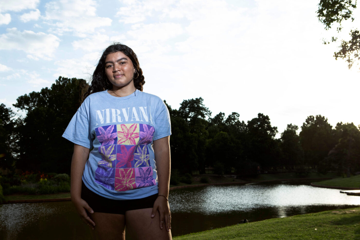 Young woman standing beside a pond at Will Rogers Gardens during an evening photography walk.