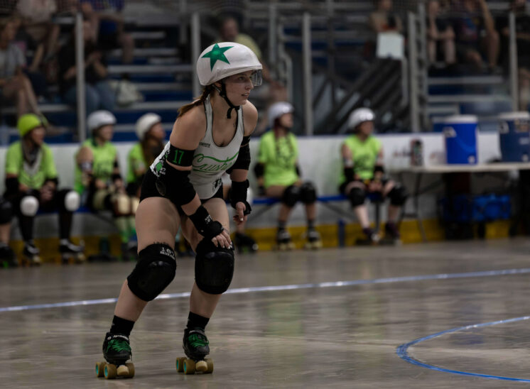 Capital City Crushers skater waits in an athletic stance during a roller derby match at Arctic Edge Ice Arena.