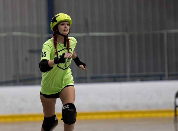 Capital City Crushers and Twister City Roller Derby Outlaws skaters compete for position during a tightly contested roller derby jam.