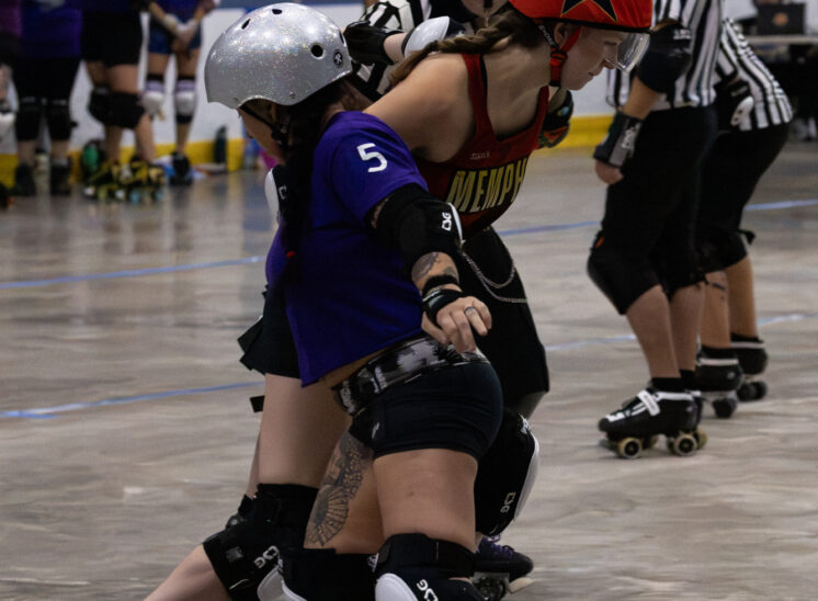 Memphis B-Sides and Twister City Lightning Quads skaters battle shoulder-to-shoulder during roller derby action.