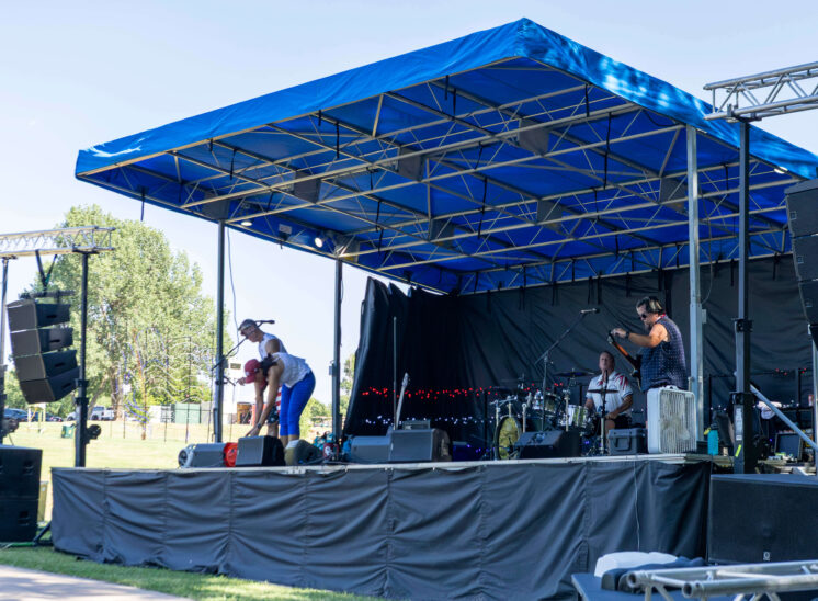 Members of Super Freak preparing equipment on stage before their performance.