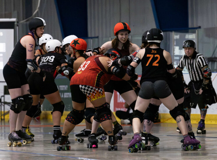 Twister City and Memphis A skaters form a crowded pack while officials observe the action.