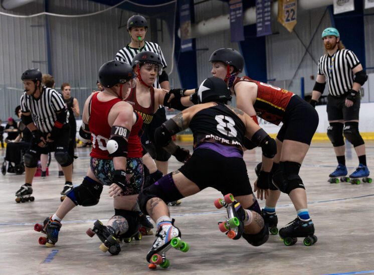 Twister City and Memphis A skaters collide in a tightly contested pack during roller derby action.