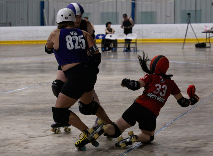 Twister City skater Flex #825 collides with Memphis B-Sides skater #33 near the track boundary.