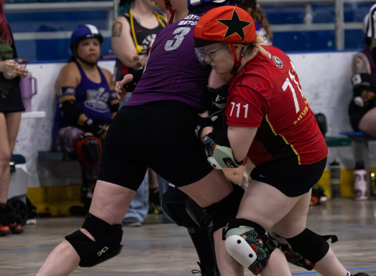 Memphis B-Sides blocker #711 applies pressure against a Twister City skater during pack action.