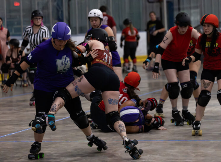 Memphis B-Sides blocker #31 engages a Twister City Lightning Quads skater as action unfolds during a roller derby jam.