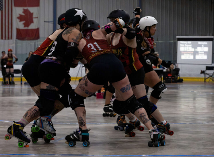 Twister City and Memphis A blockers engage in a physical pack while the scoreboard glows in the background.