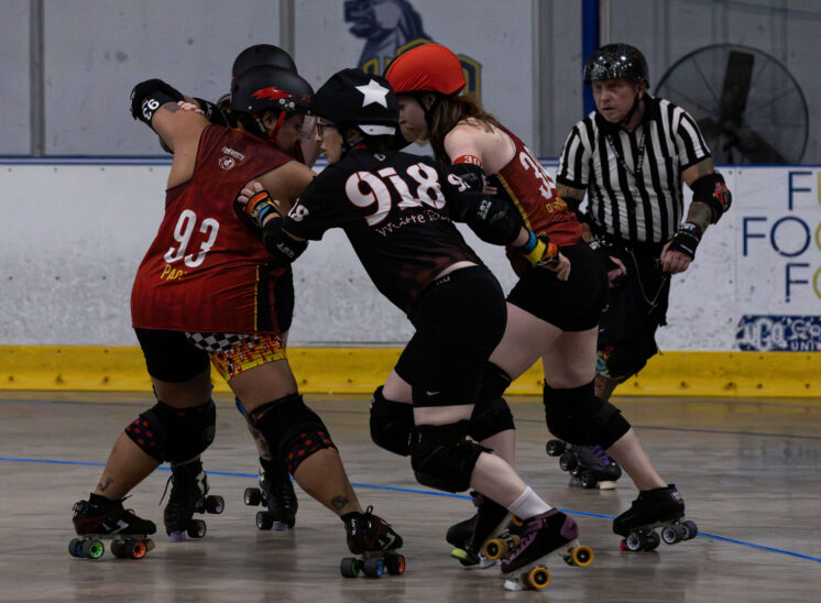 Memphis A and Twister City skaters battle shoulder-to-shoulder near the edge of the track.